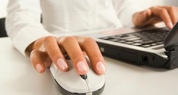 Picture of a Persons Hand Hovering over Computer Mouse next to a Keyboard