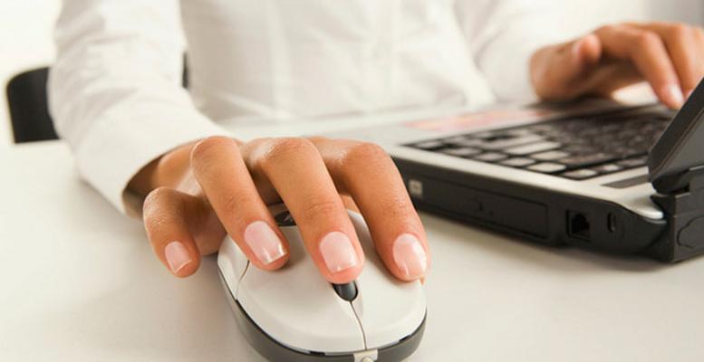Picture of a Persons Hand Hovering over Computer Mouse next to a Keyboard