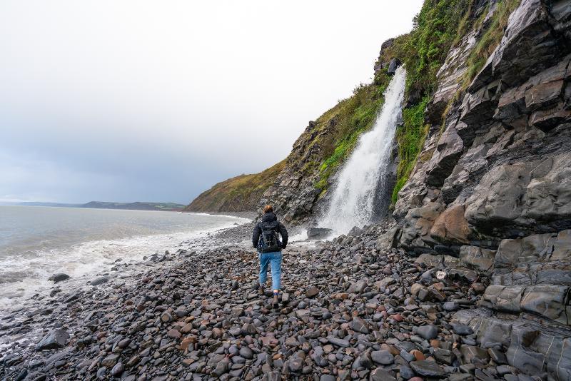 Bucks Mills person walking by waterfall