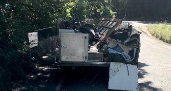 photo of a cut down caravan, which has been converted into a makeshift trailer filled with rubbish