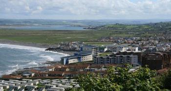 Figure 2.20: A caravan park and flats in the foreground with houses, fields and sea behind.