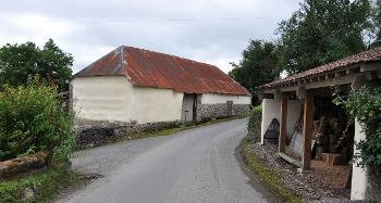 LCT 3G Isolated farm building on winding lane with characteristic local vernacular of cream/whitewash and exposed stone.