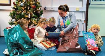 Children Ava, Rosa, Reggie, Oakley and Teresa from the Recycling team sat together on the floor with recycling bags