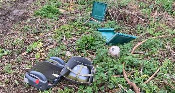Items that have been thrown and dumped, including a children's car seat