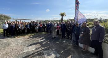 Officers and Councillors gathering by the Riverbank House flagpole to commemorate VE day. 