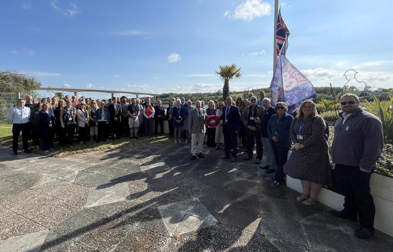 Officers and Councillors gathering by the Riverbank House flagpole to commemorate VE day. 