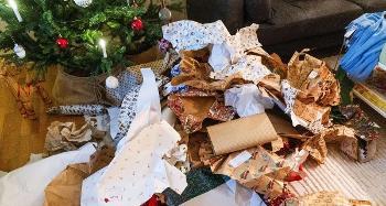 Screwed up and open wrapping paper under a Christmas tree