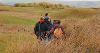 A panoramic view on the Northam Burrows in winter with a small group of people walking away from the camera wearing warm coats