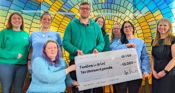 Group of people holding a cheque for £10,000