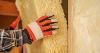 Image of a builder or contractors hand wearing PPE working on a wall